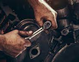 Mechanic's hands working with a spanner on a diesel engine